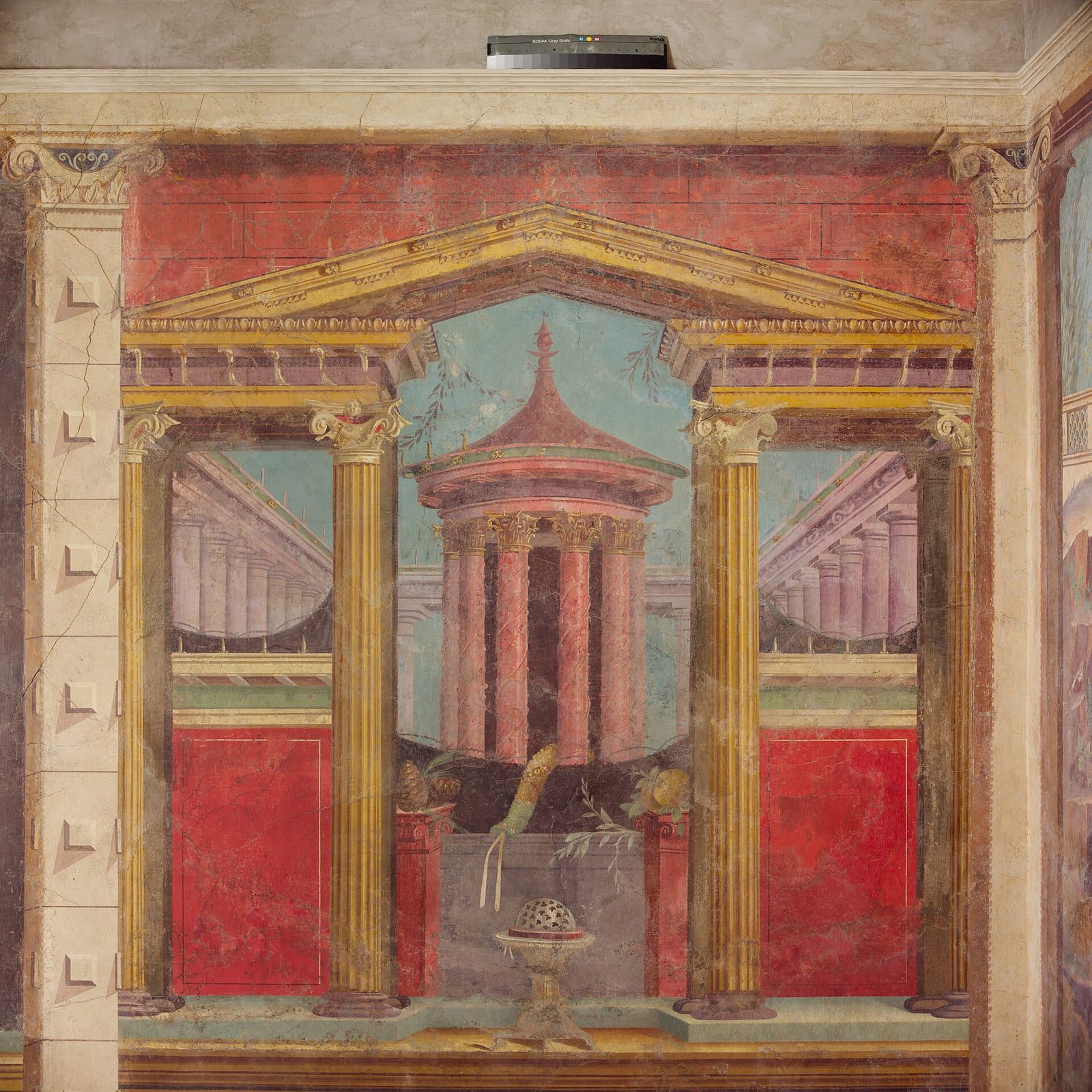 Two painted walls meeting at a corner, the false columns and cornices lining up so the room appears deeper than it is