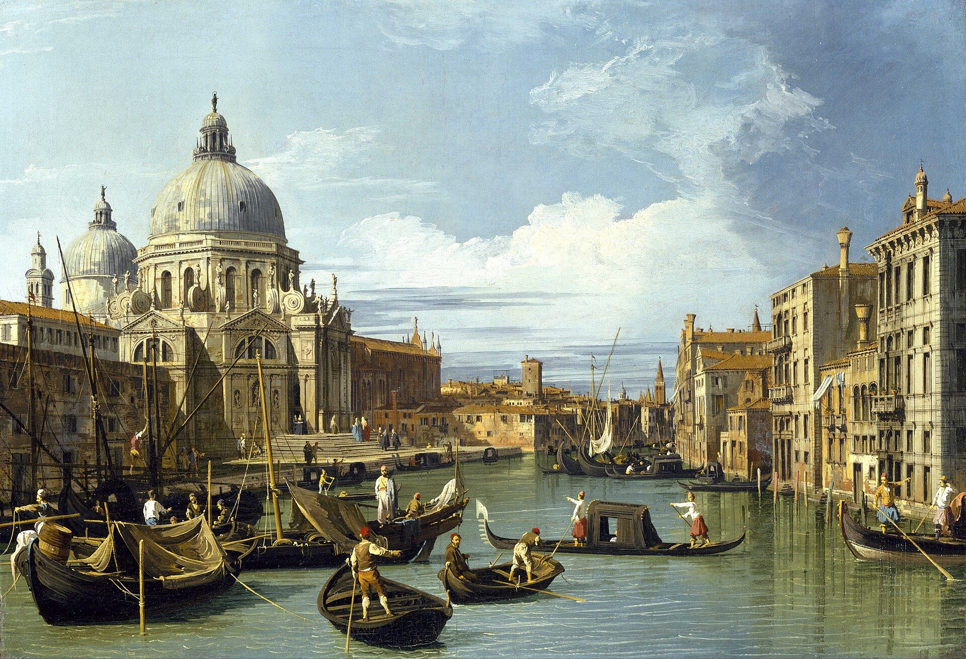The domed church of the Salute across the mouth of the Grand Canal, gondolas and moored boats in the foreground under a bright clouded sky
