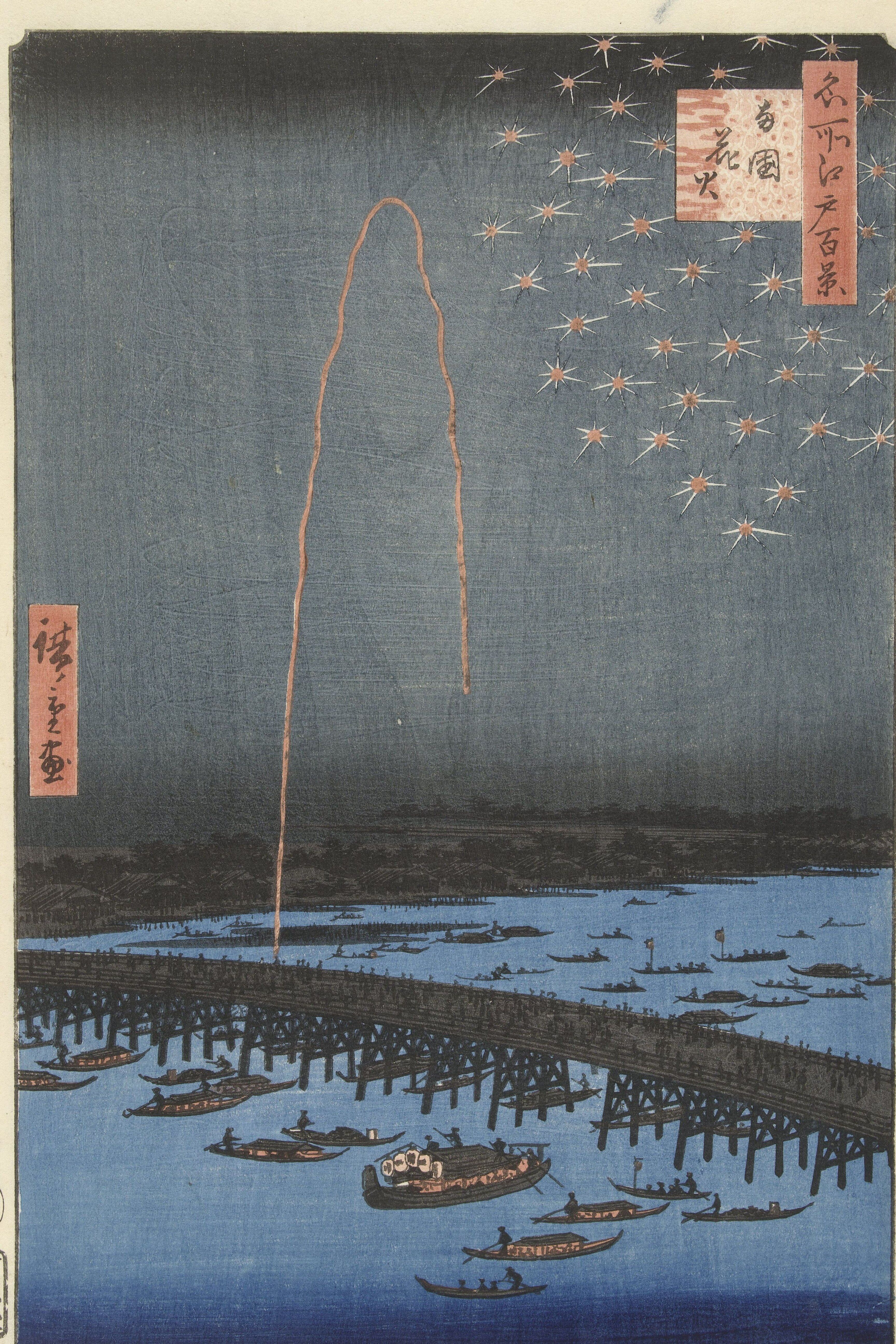 Night view of a river, gold firework trails scattering across a dark blue sky above a crowded bridge and a fleet of small boats