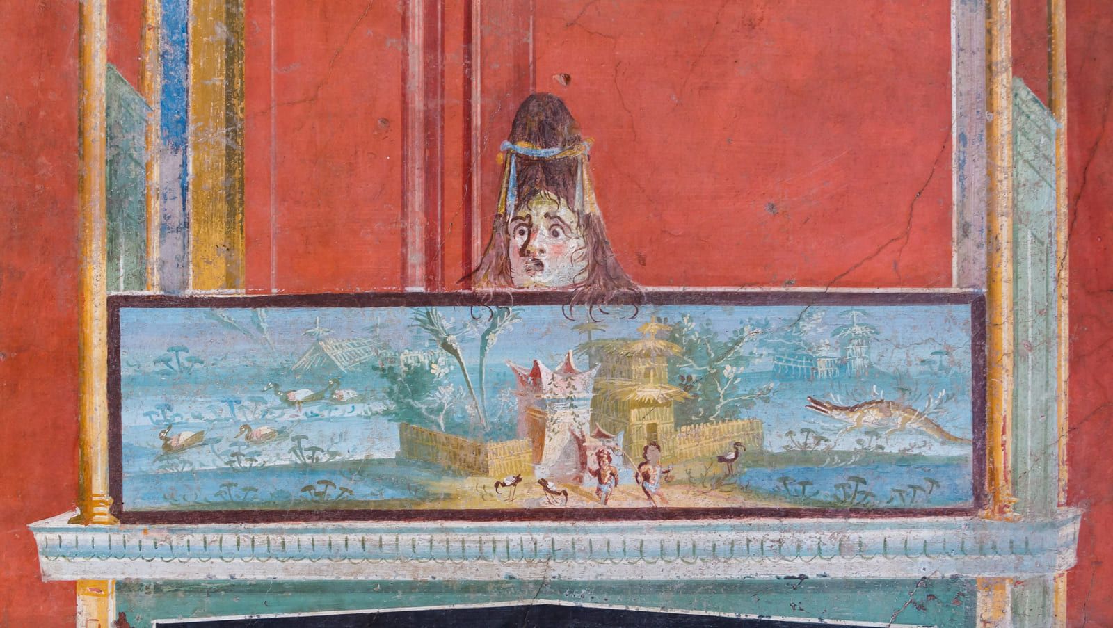 A small pale landscape of water, reeds and low buildings set like a picture into a deep red painted wall