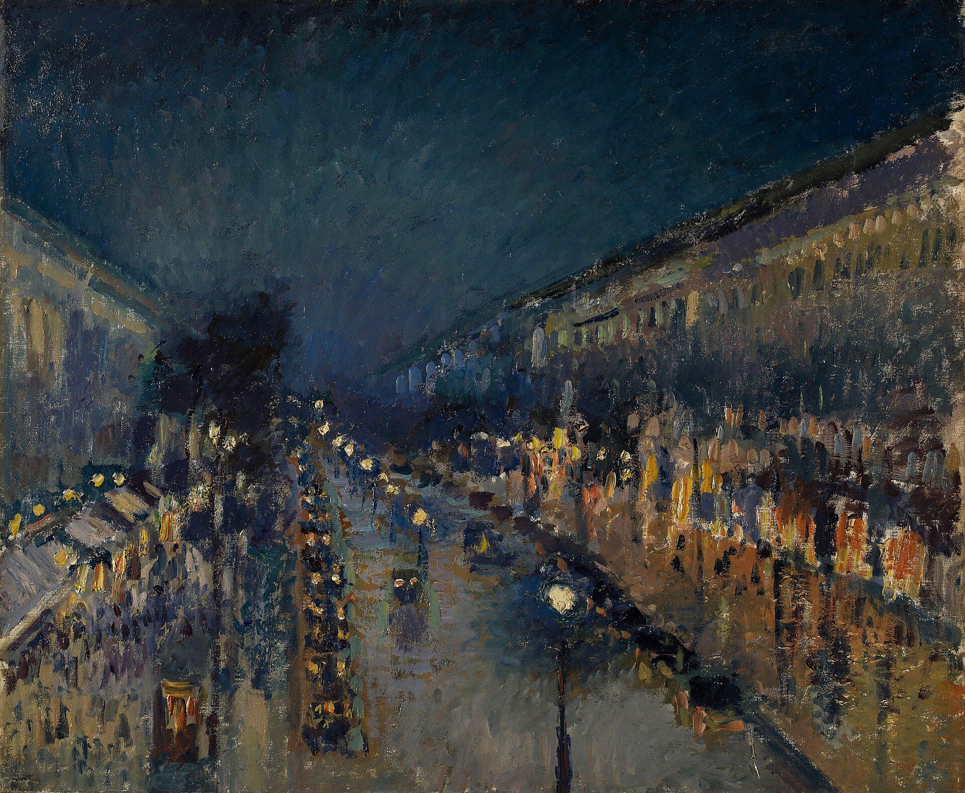 A wet Paris boulevard at night seen from above, shop windows and street lamps doubled in long streaks across the road under a deep blue sky
