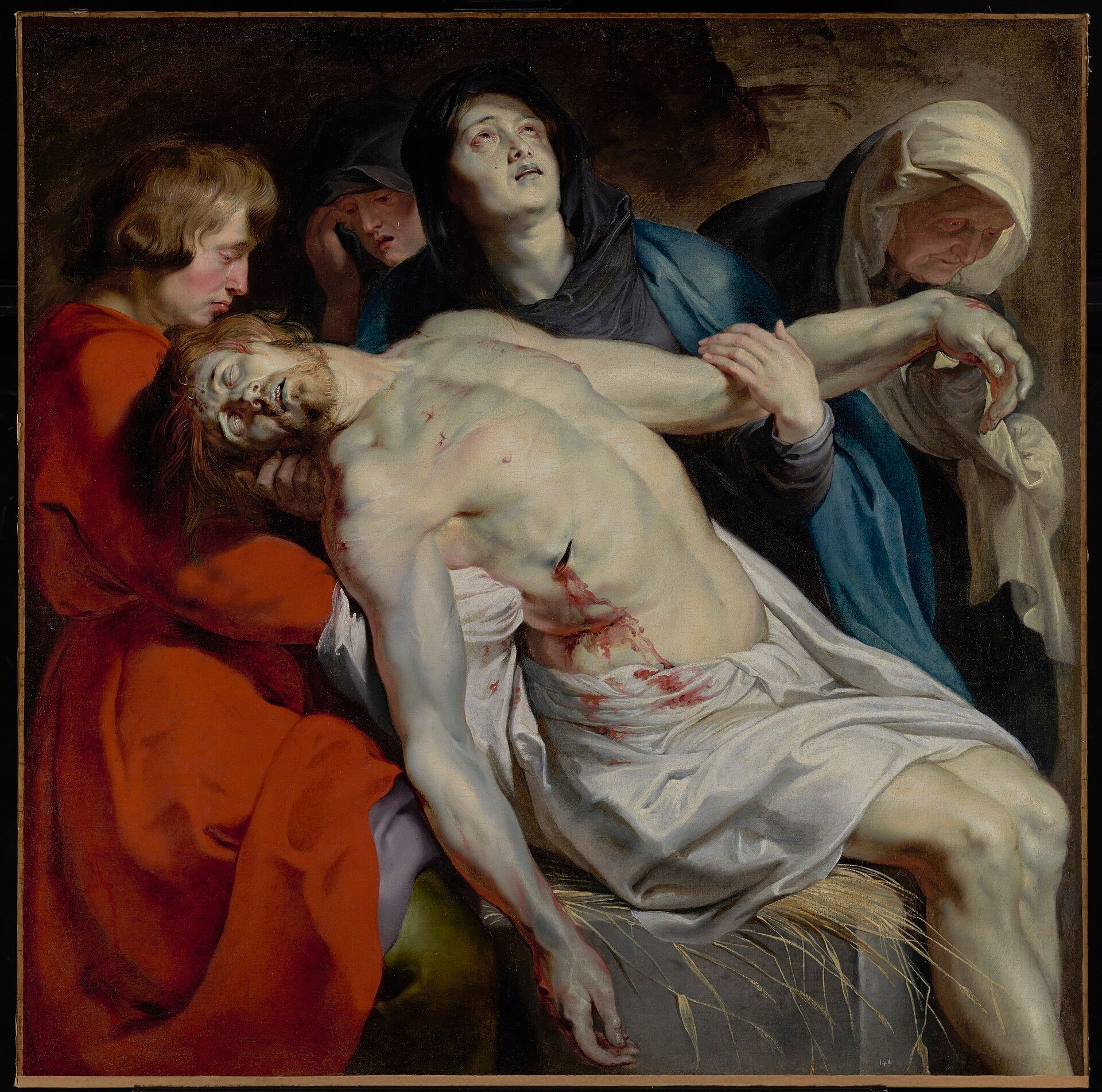 The dead Christ lowered onto a stone slab strewn with wheat, a youth in red taking his shoulders and an old woman lifting his arm