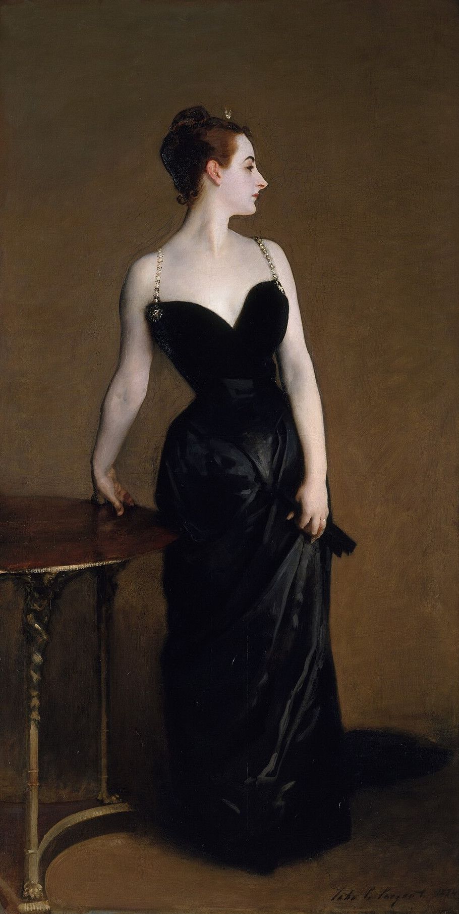 A woman in a black satin gown standing in profile against a plain brown ground, one hand resting on a small table, her skin painted very pale