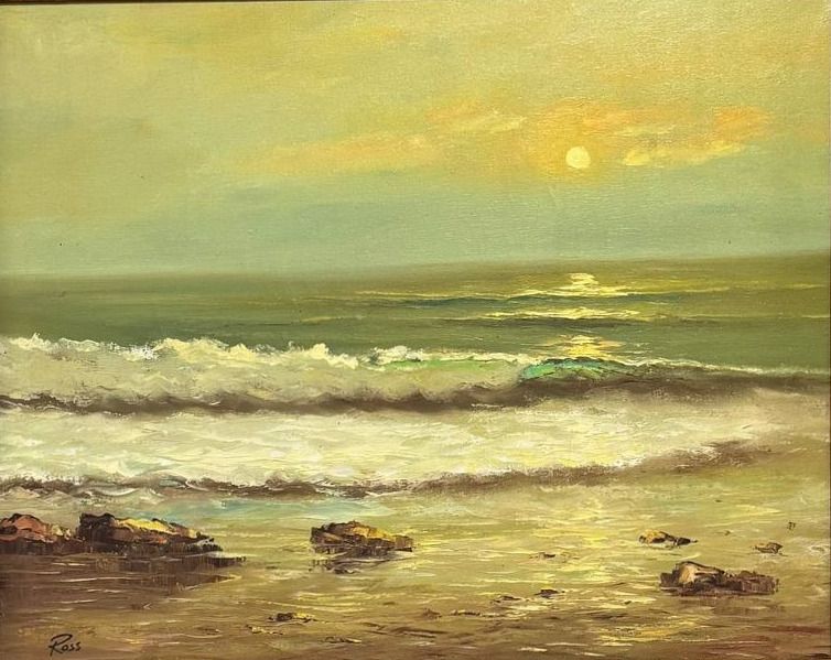 Sunset seascape with breaking surf running over dark rocks