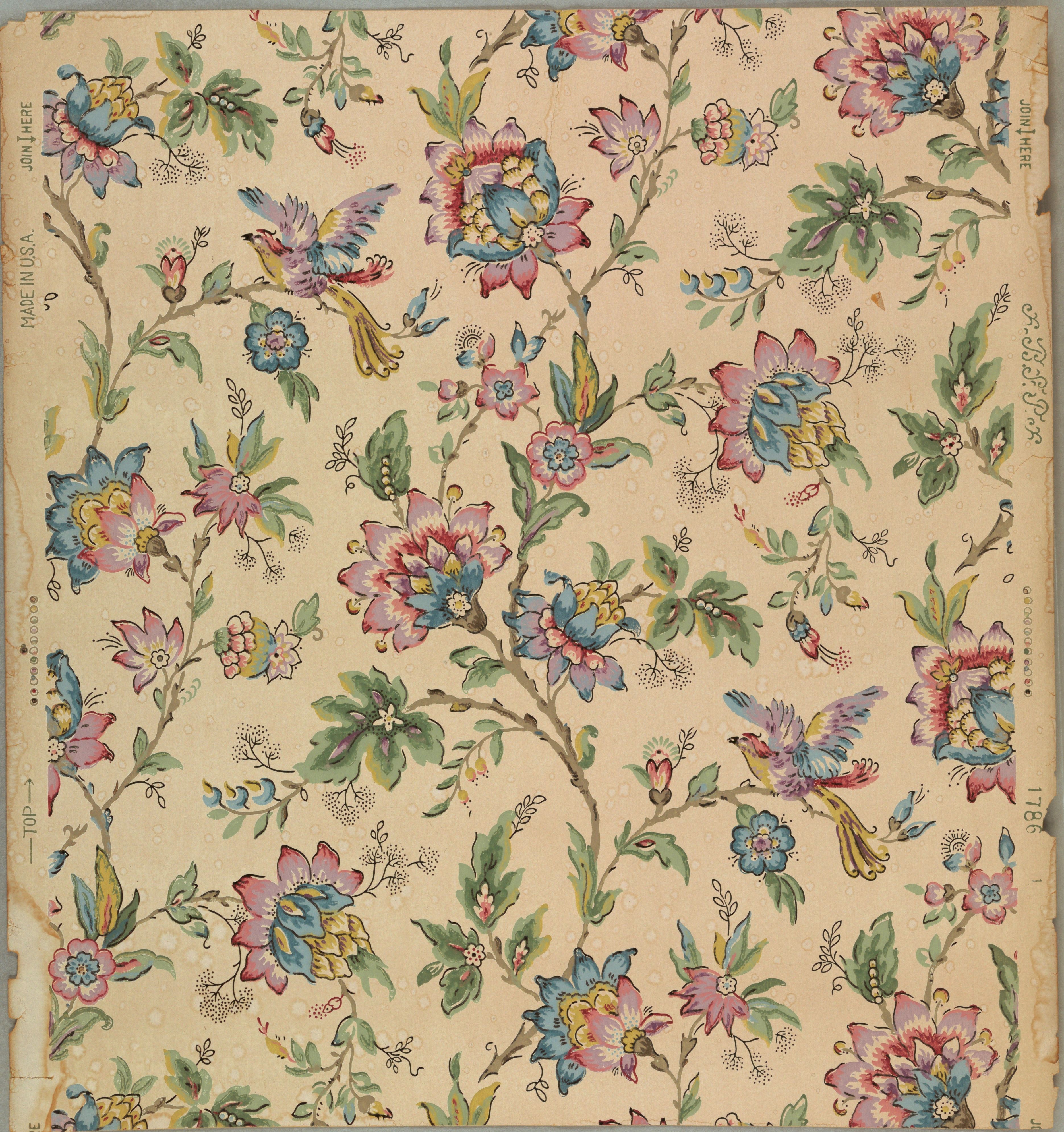 Small birds among pink, blue and violet flowers on scrolling green stems, scattered evenly across a pale coral ground