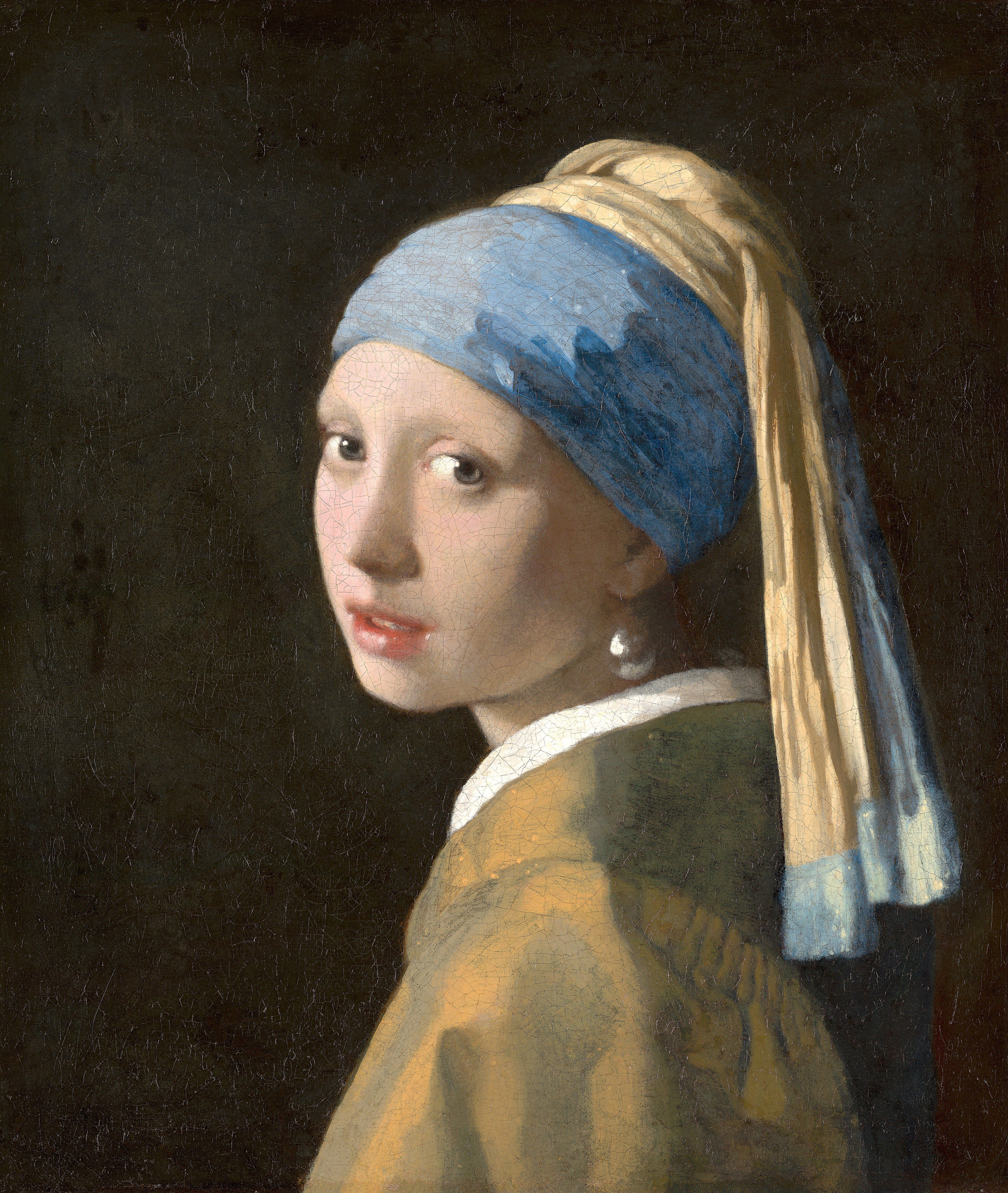 A girl in a blue and gold turban turns to look over her shoulder out of deep darkness, a single pearl at her ear