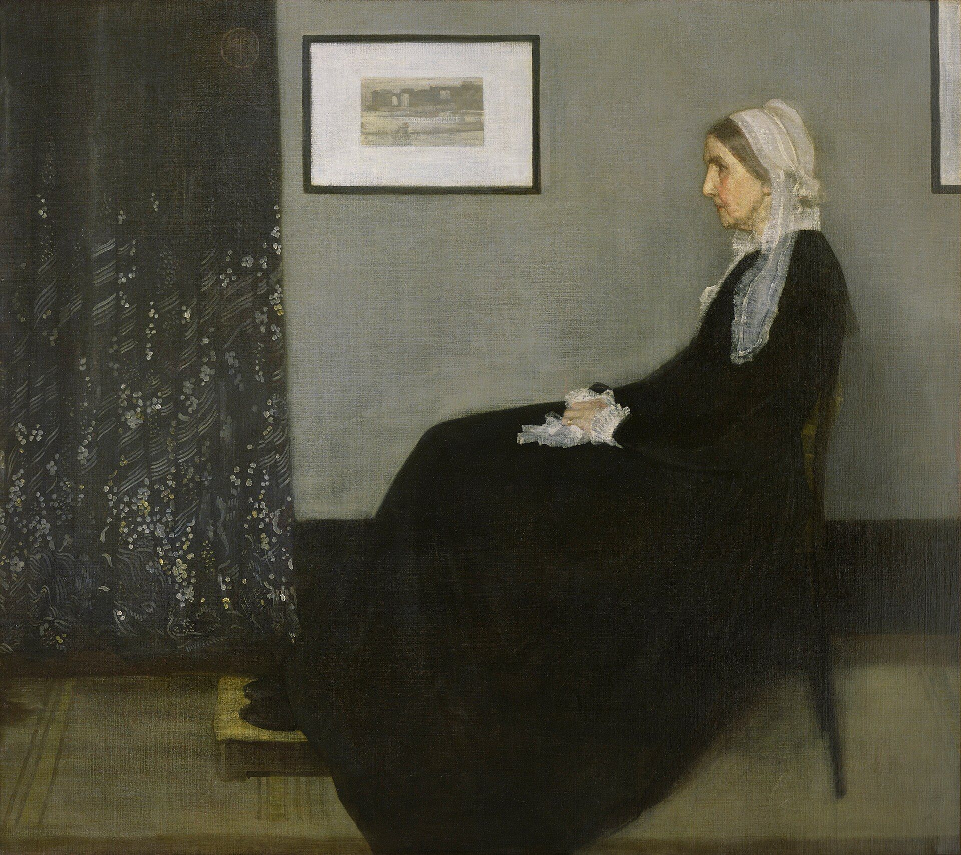 An elderly woman in a black dress and white cap seated in profile against a grey wall, a patterned curtain at the left and a framed print above her